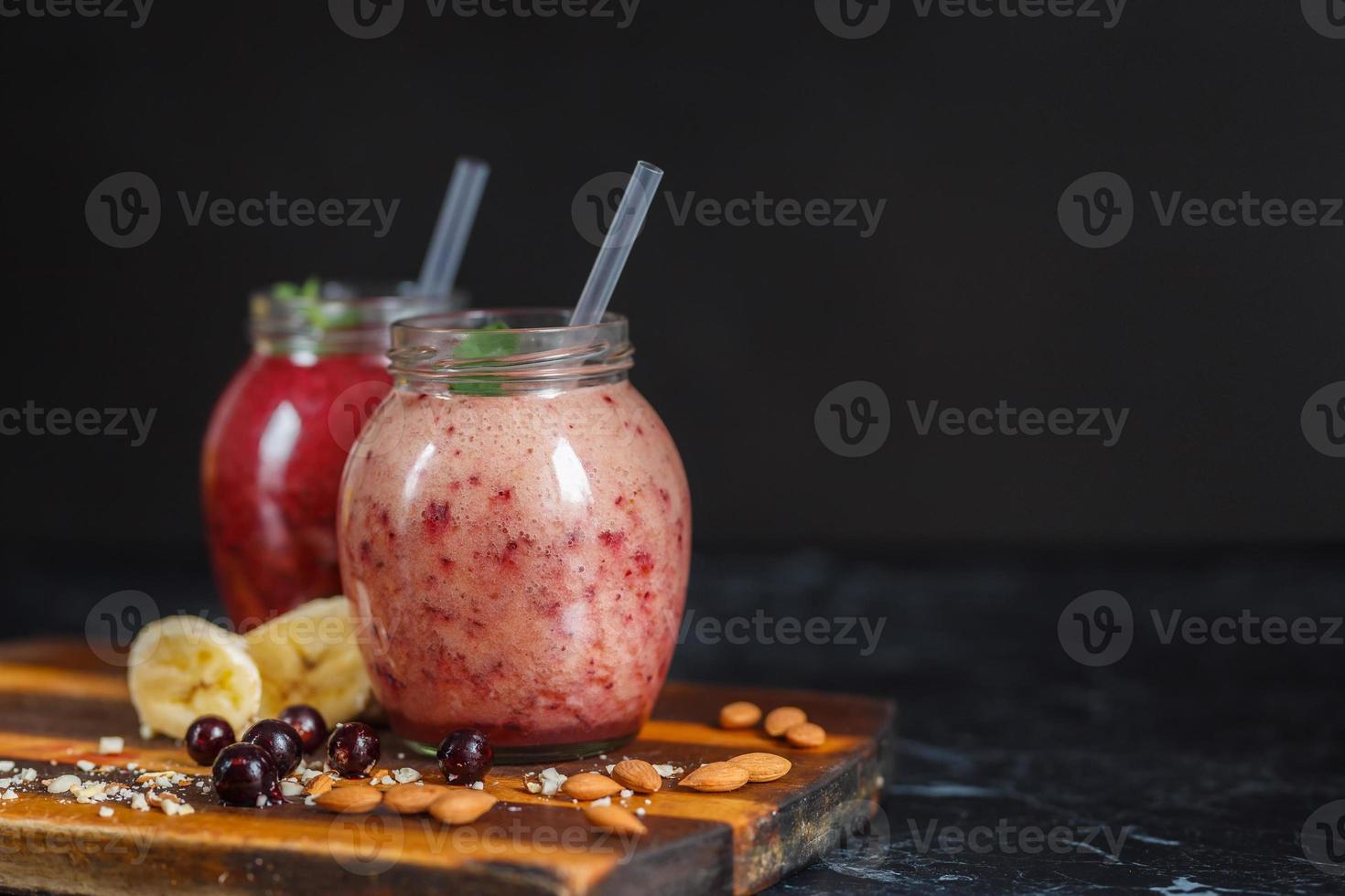 batidos recién preparados de plátano con granada y plátano con mora en botella. dieta, estilo de vida saludable foto