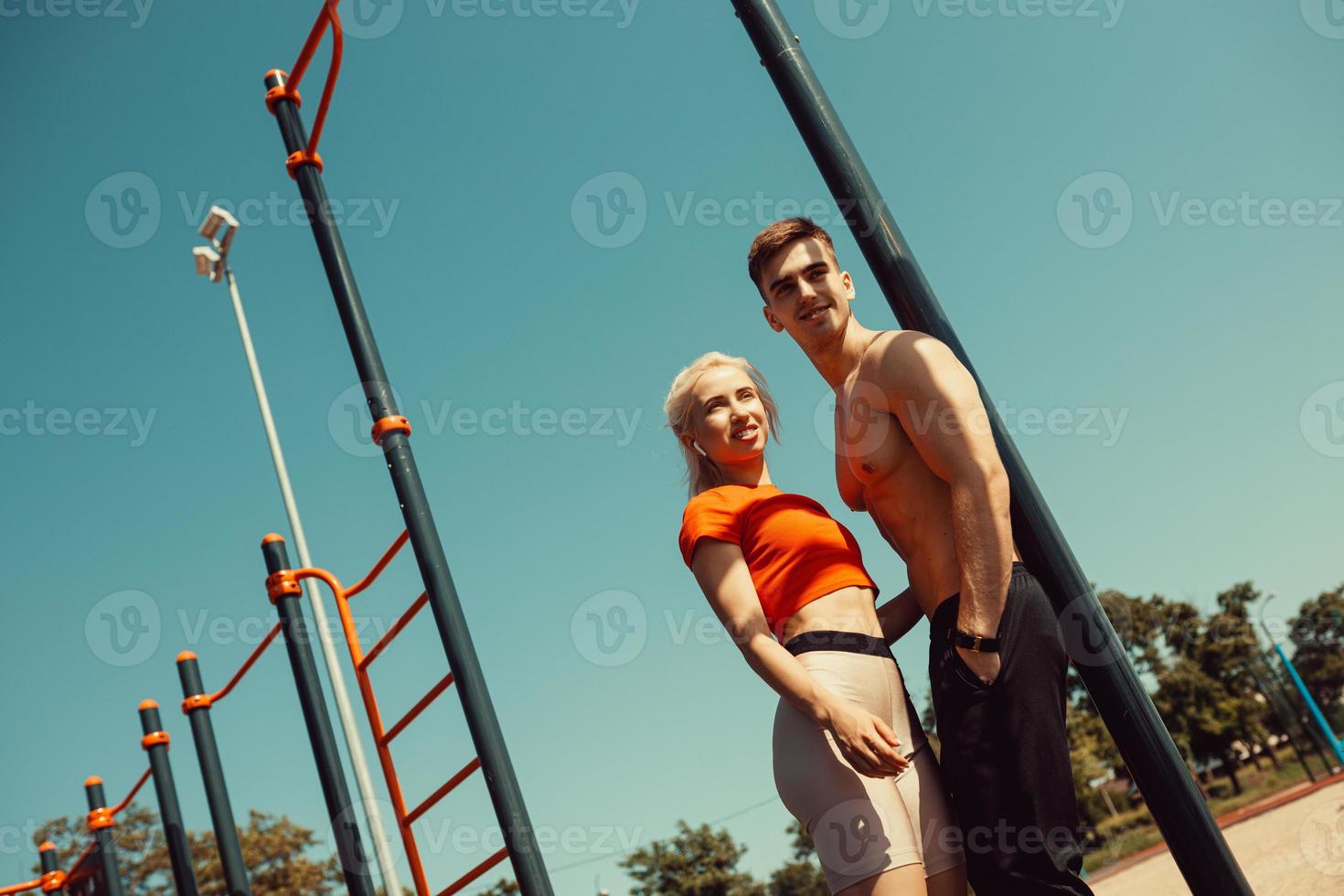 young couple communicates while standing by a horizontal bar photo