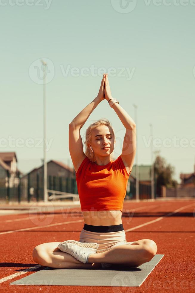 joven rubia se relaja en una alfombra deportiva foto