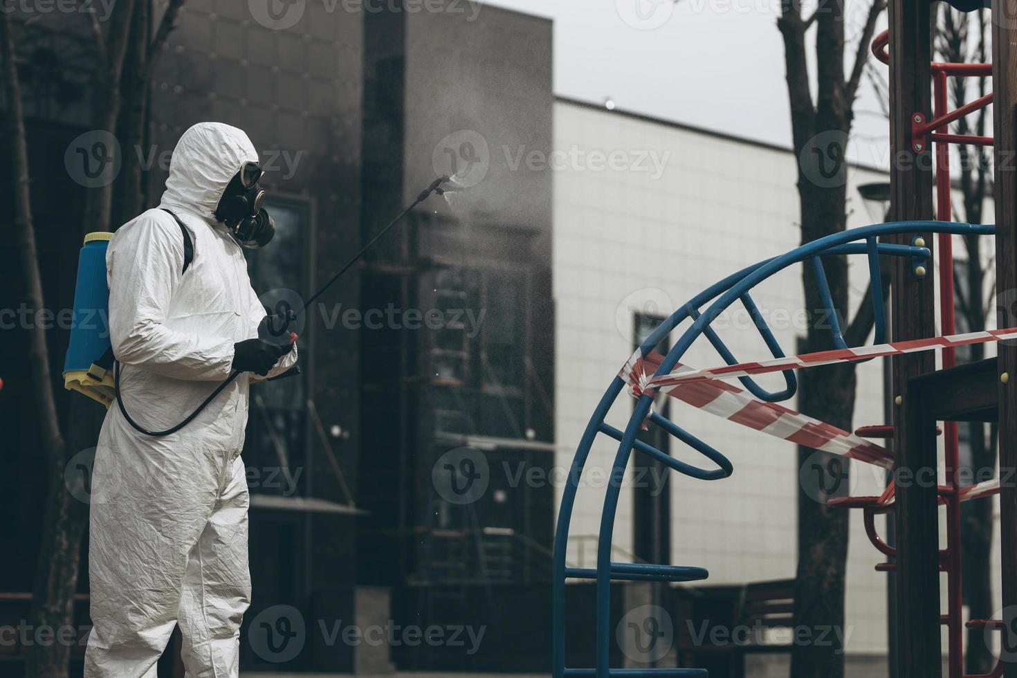 Cleaning and Disinfection on the playground in the sity complex amid the coronavirus epidemic Teams for disinfection efforts Infection prevention and control of epidemic Protective suit and mask photo