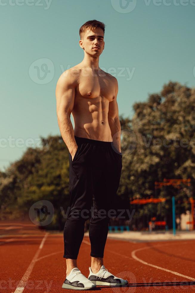 chico joven con cuerpo atlético preparándose para correr foto