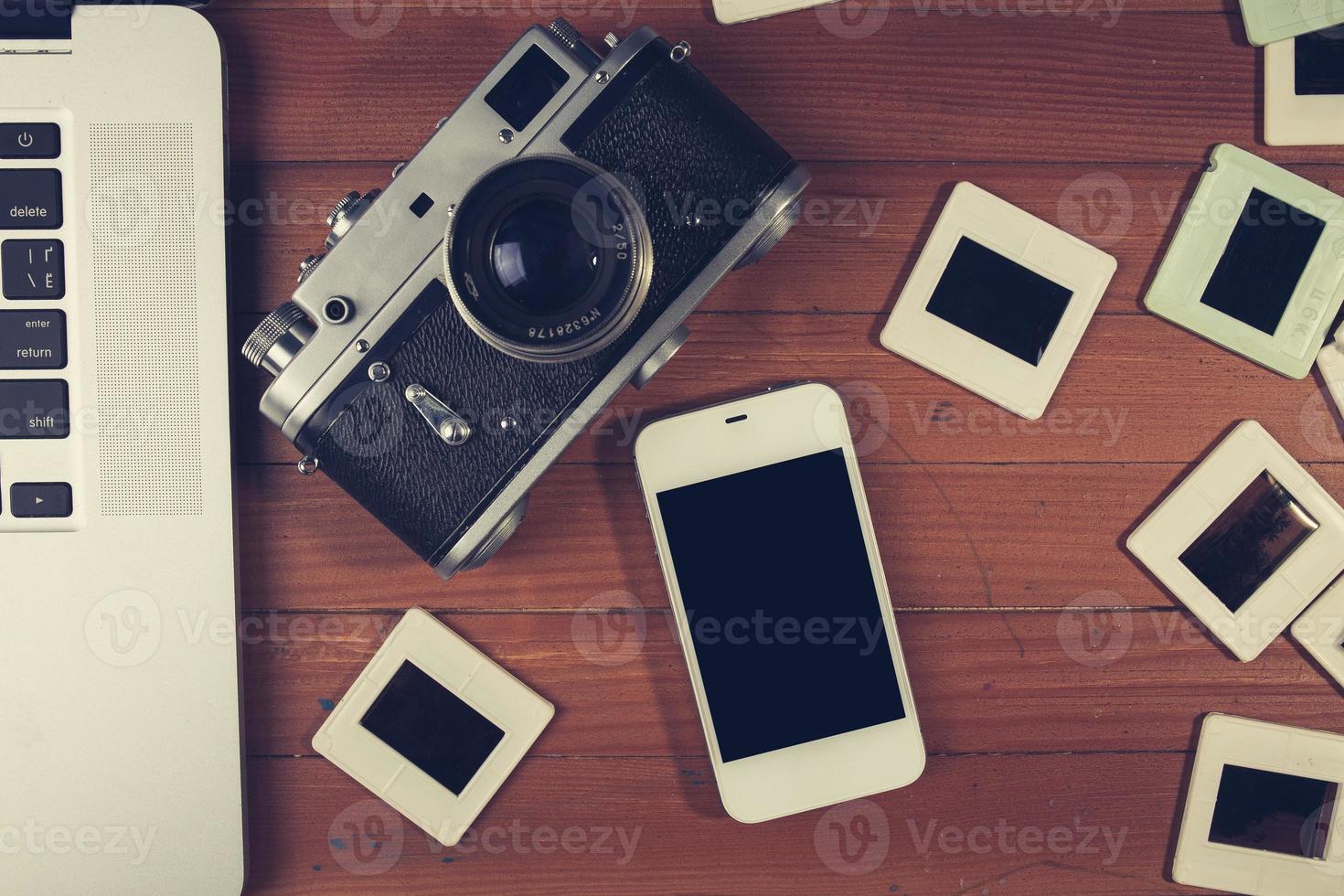 retro camera and some old photos on wooden table.