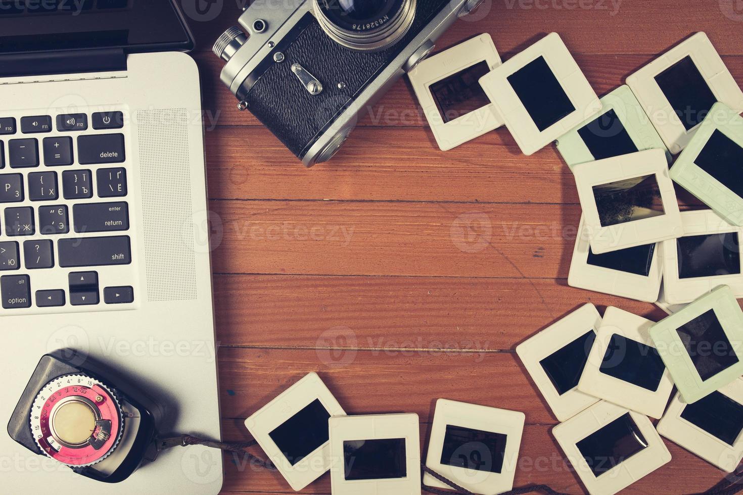 composition of old photo camera, laptop and slides