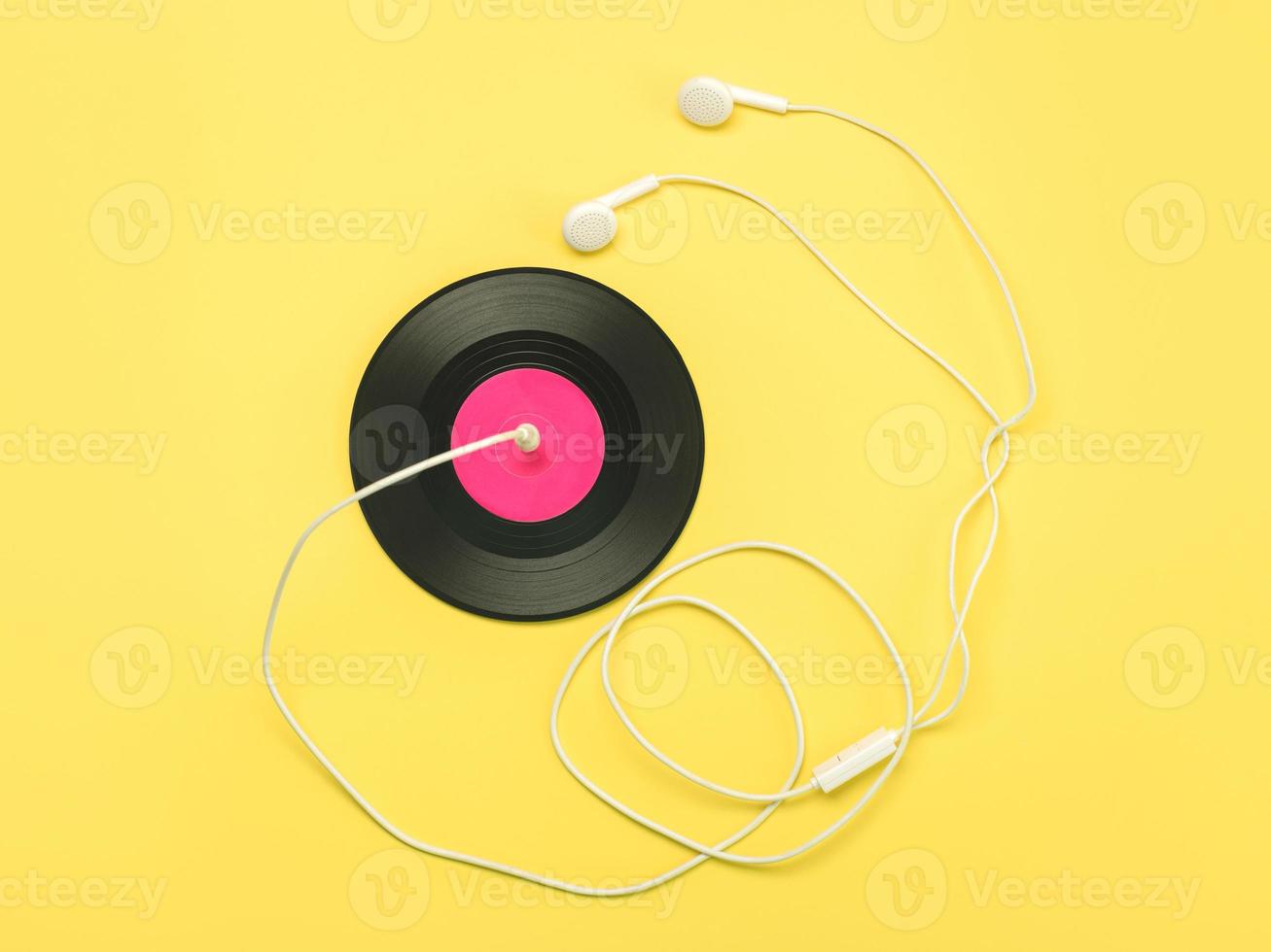 vinyl disc and a white headphones with a wire.Music concept photo