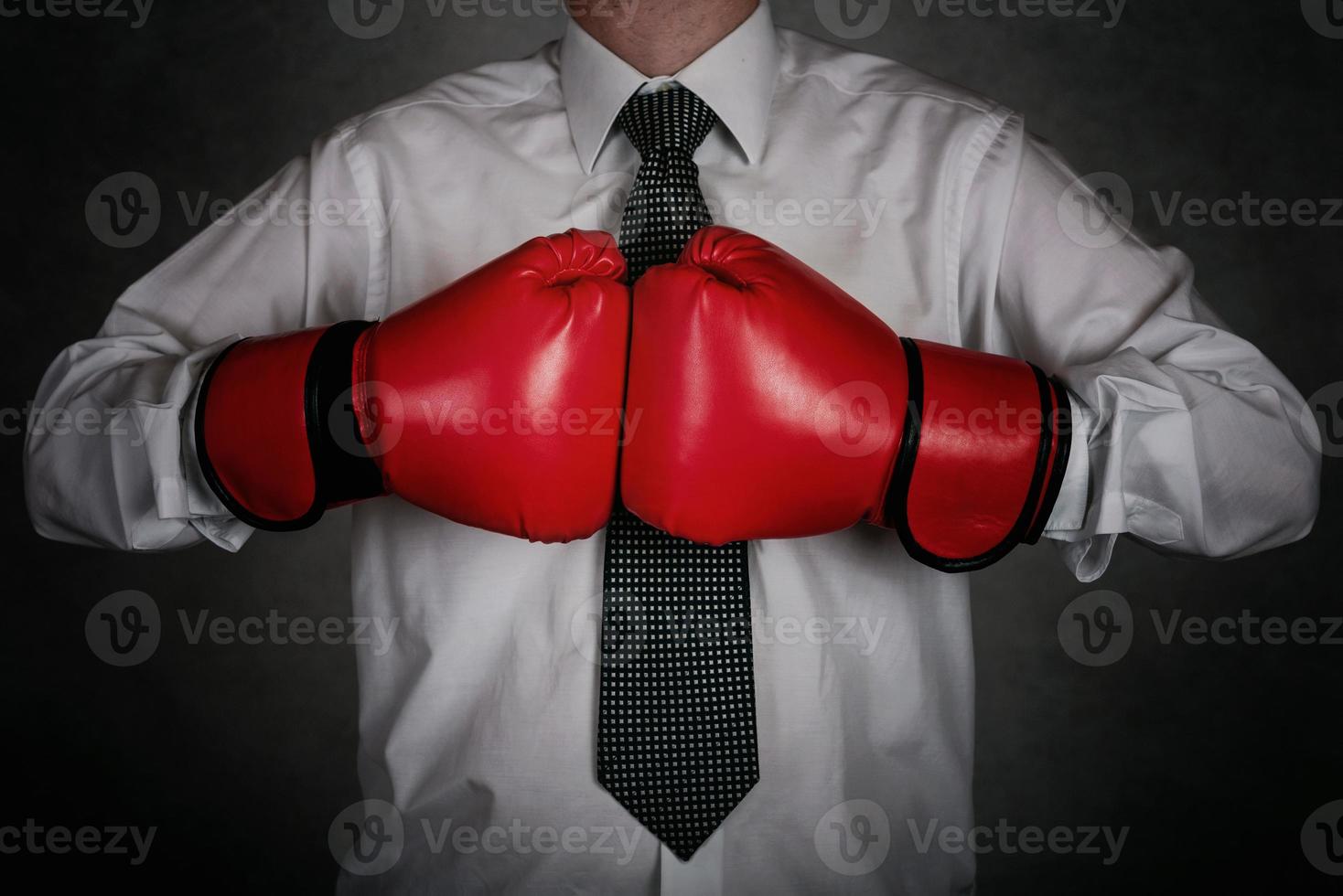 Businessman In red boxing gloves on black background photo