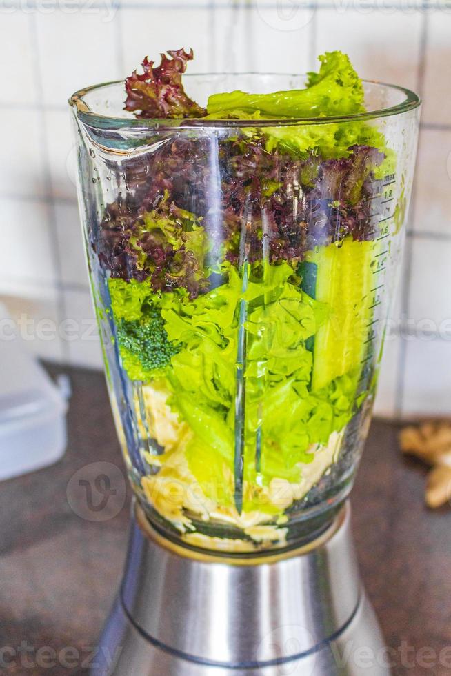 batido verde saludable con ensalada de frutas vegetales verdes en licuadora. foto