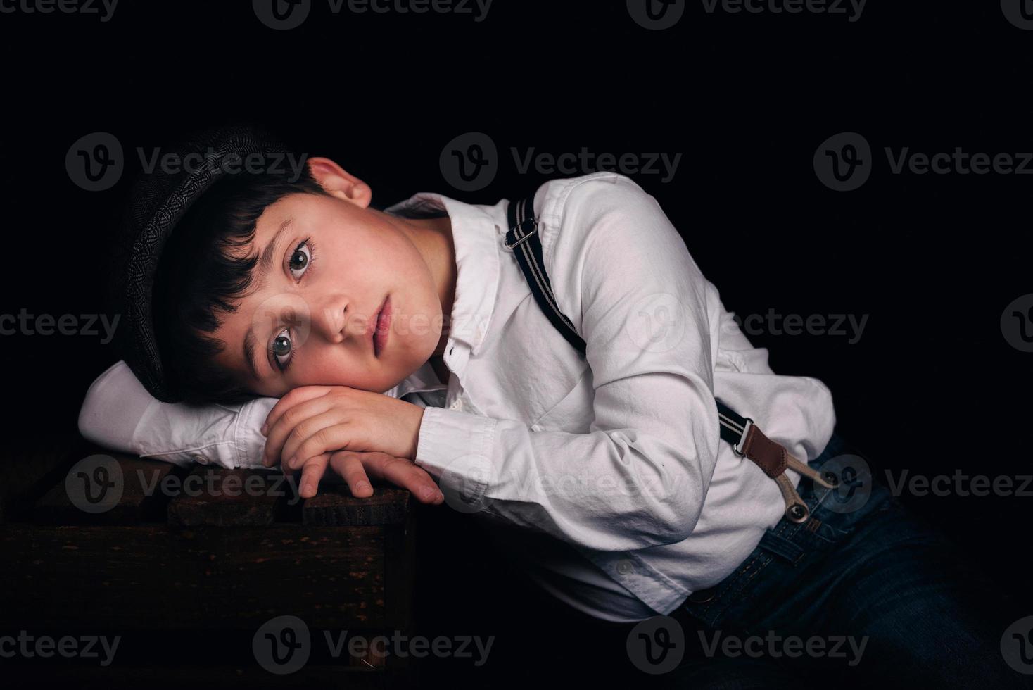 Pensive boy on black background photo