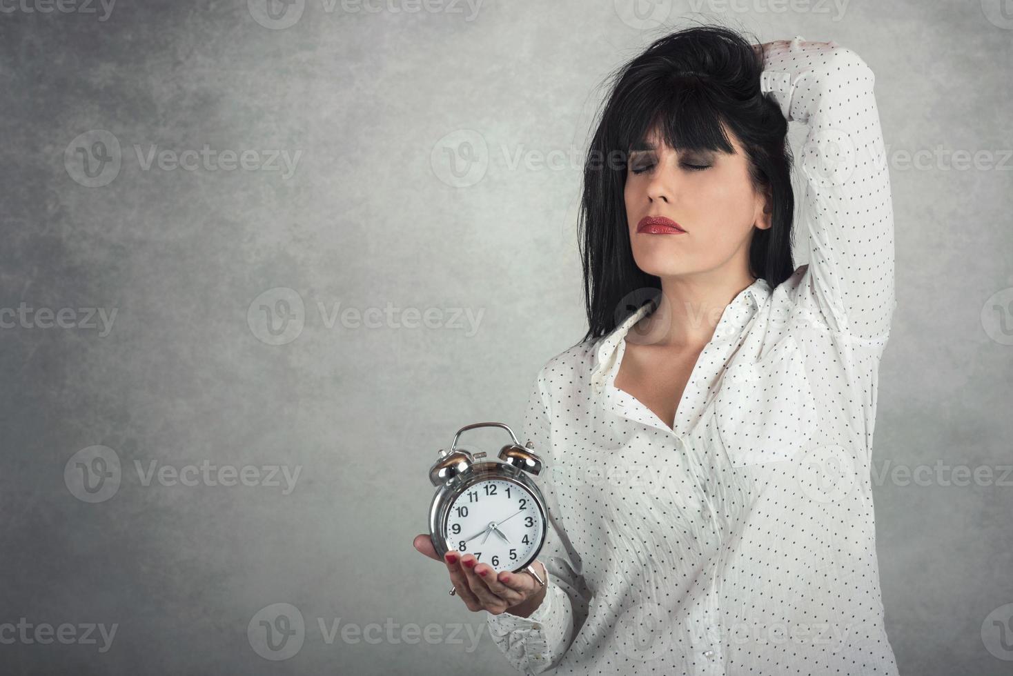 Sleeping woman holding clock photo