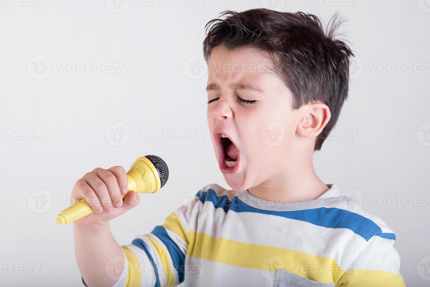 chico cantando con un microfono foto