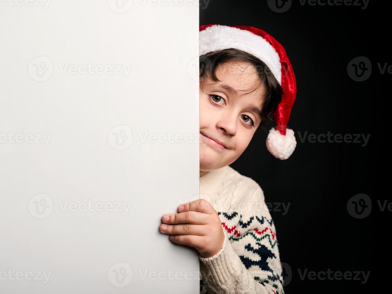 niño feliz en Navidad junto a un cartel foto