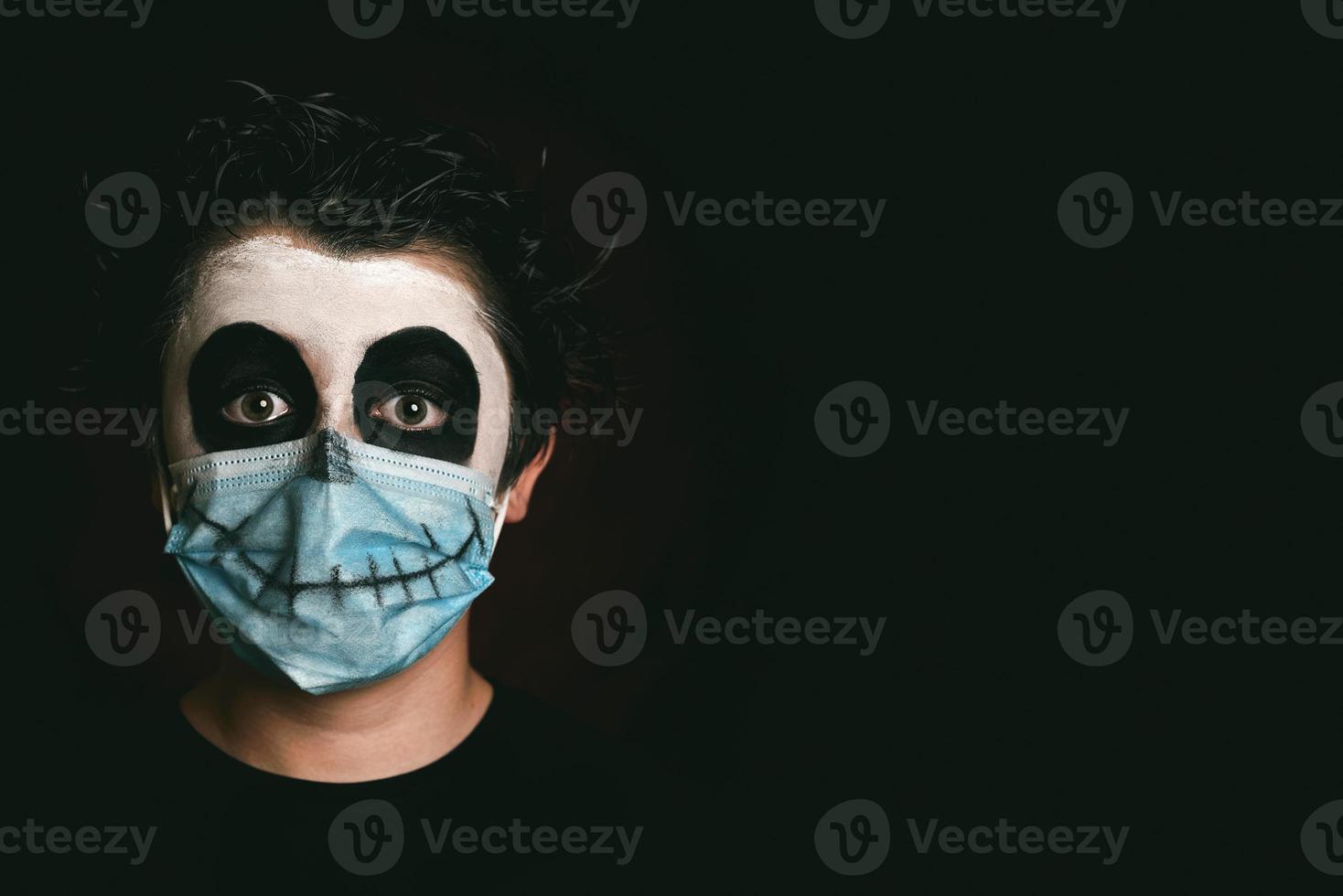 Happy Halloween.Close-up of kid wearing medical mask in a skeleton costume photo