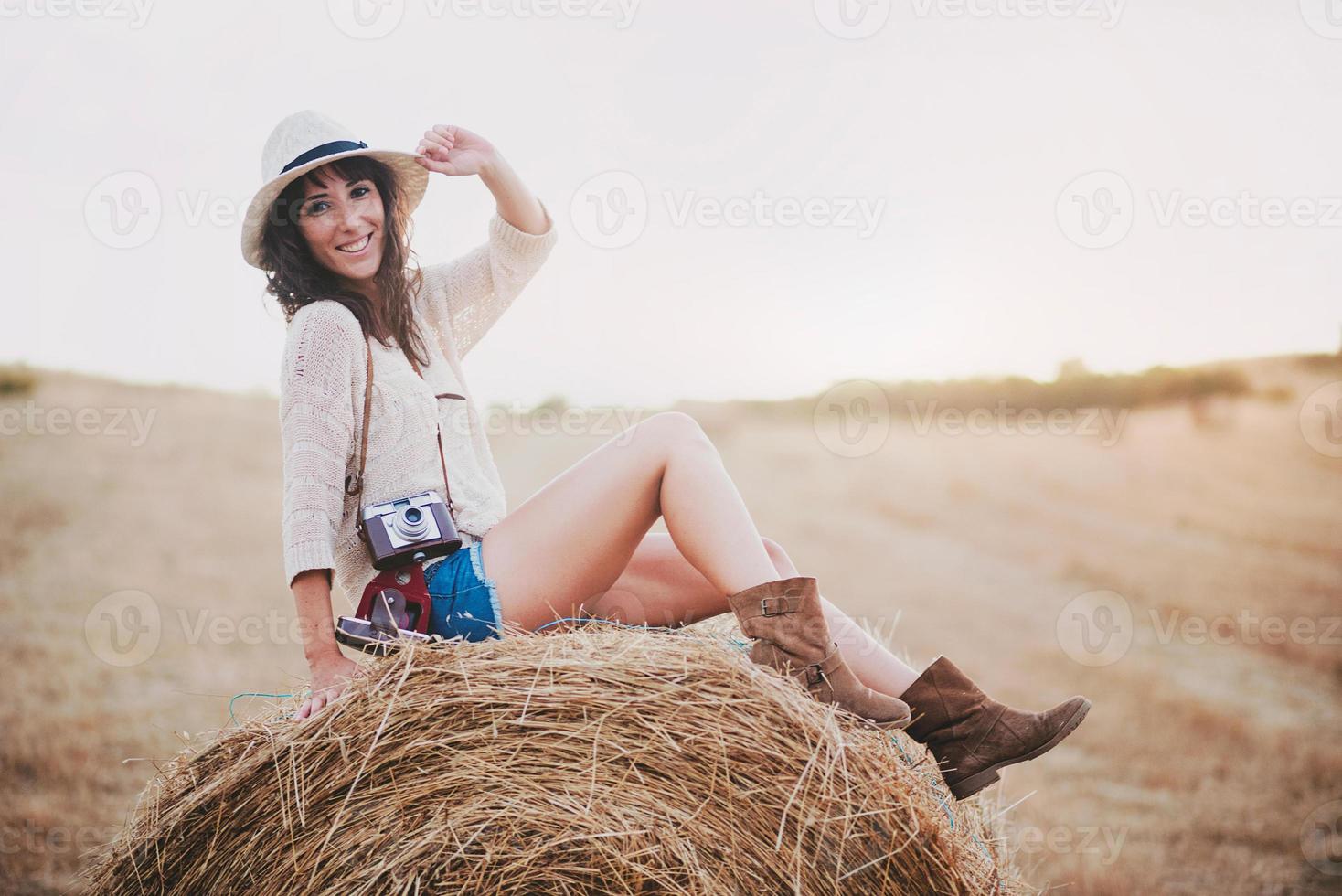 Smiling girl sitting on the straw photo