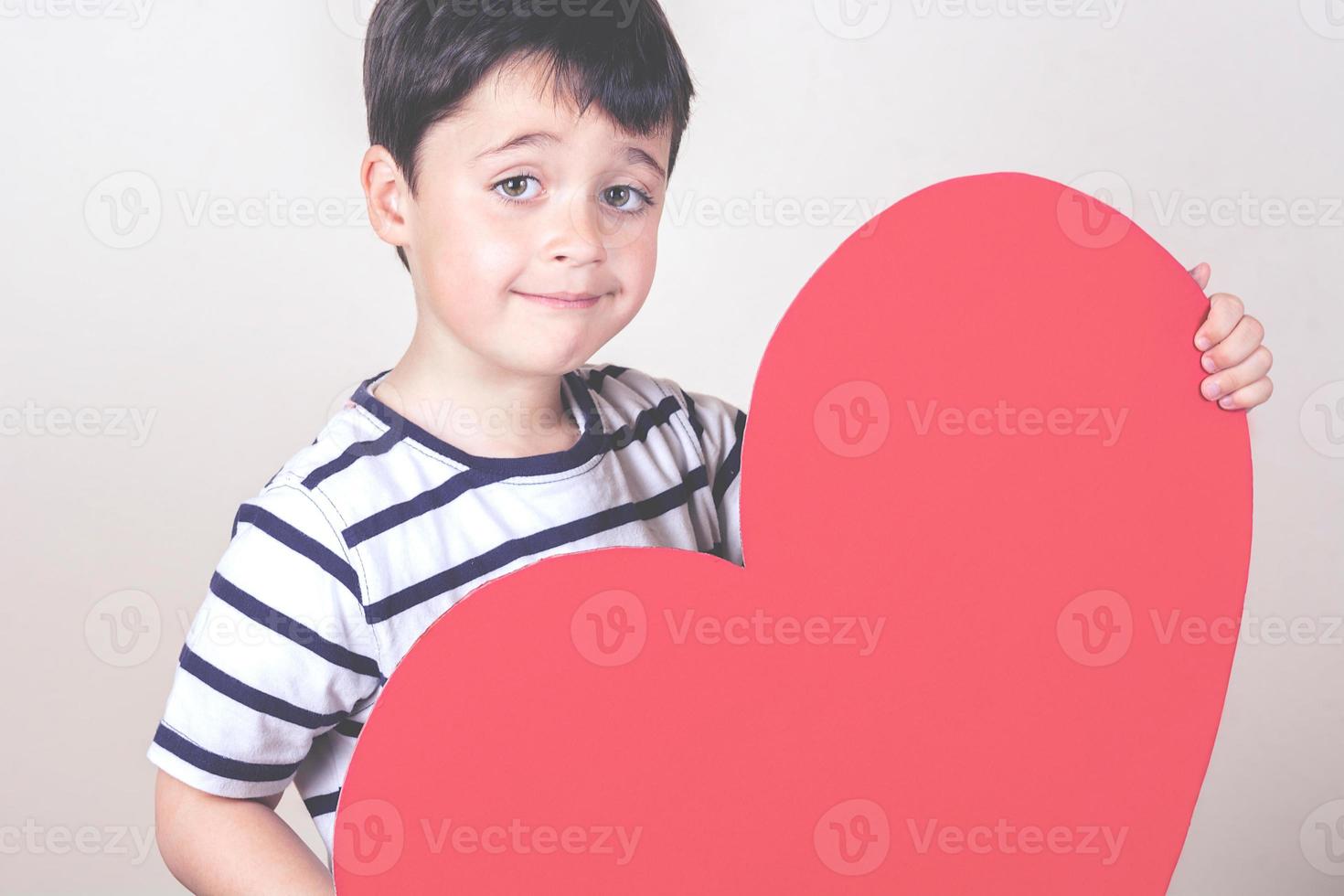 niño feliz con un corazón rojo foto