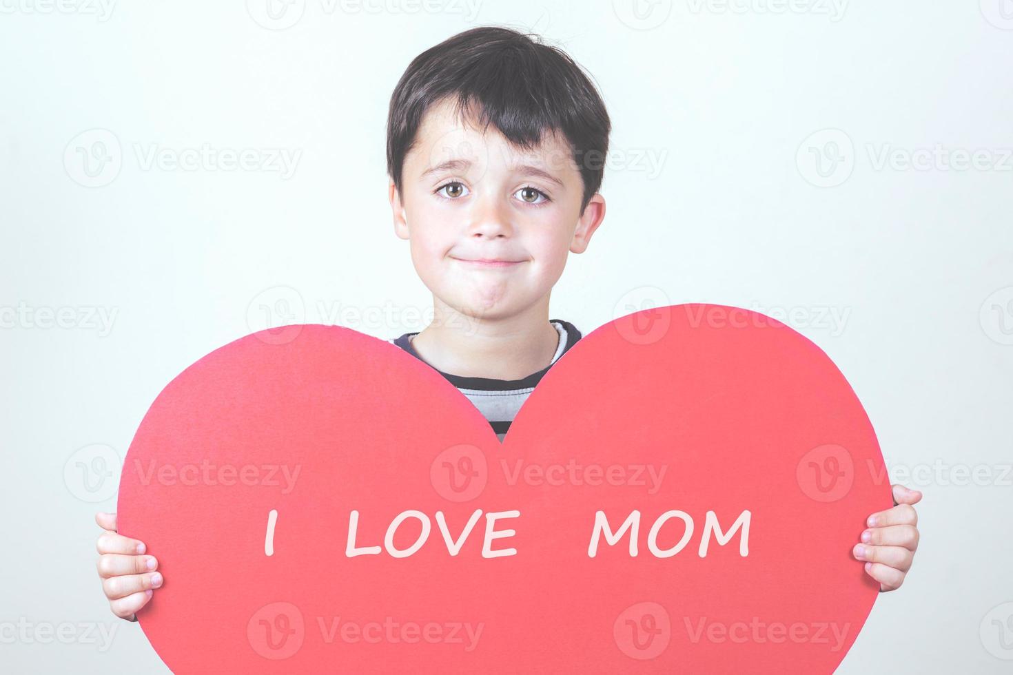 amo a mamá, niña feliz con un corazón rojo foto
