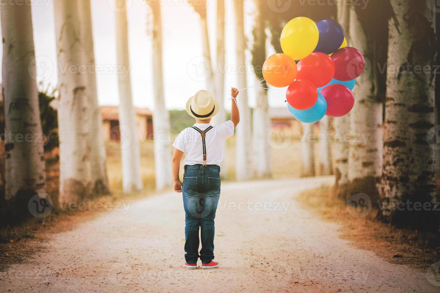 thoughtful boy with balloons in the field photo