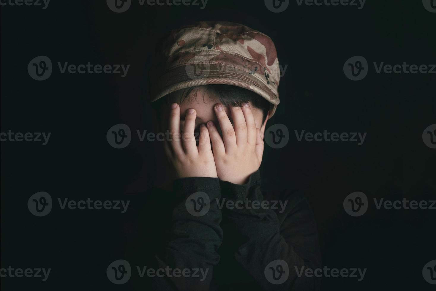 Scared boy on black background photo