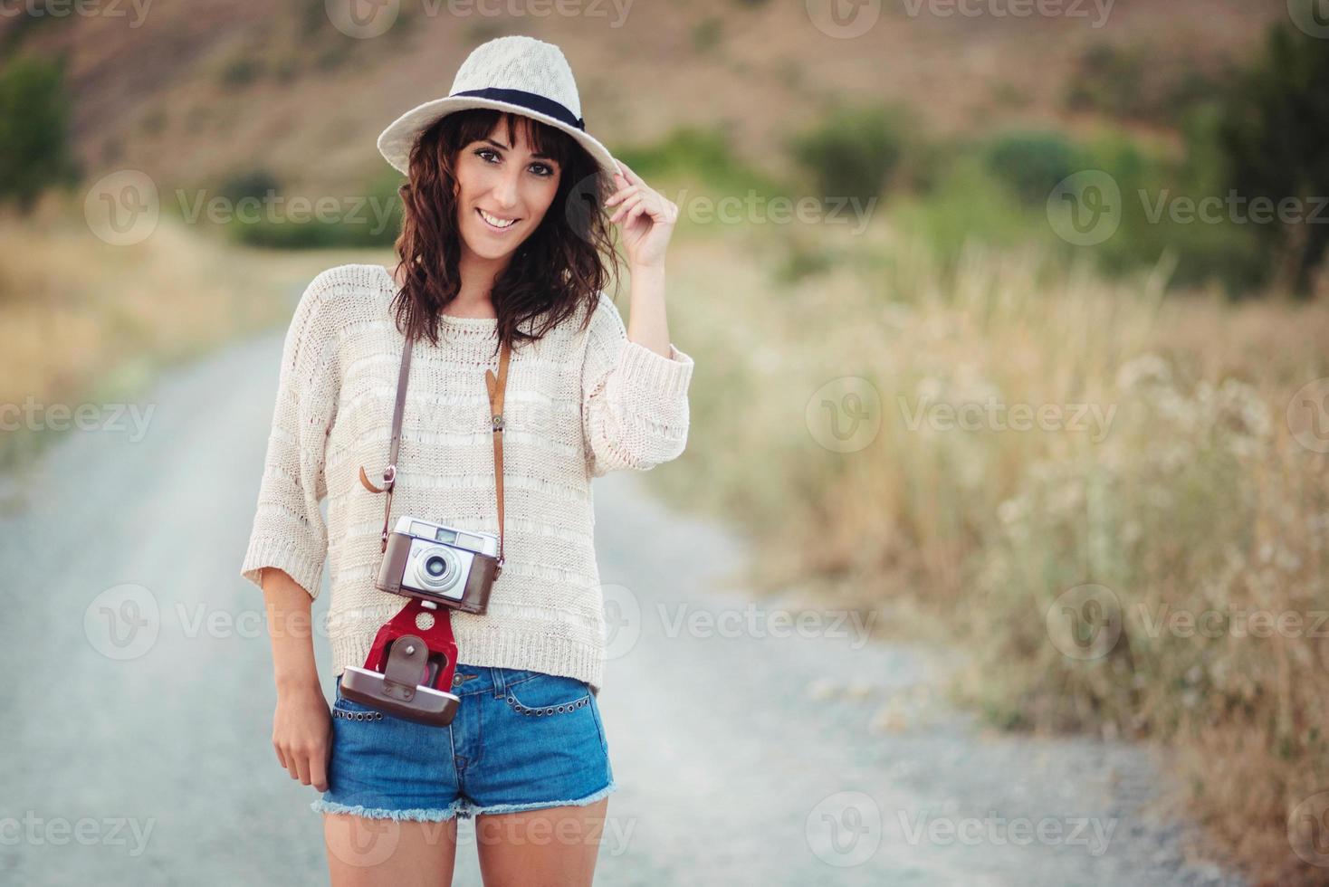 Smiling girl with camera in the field photo