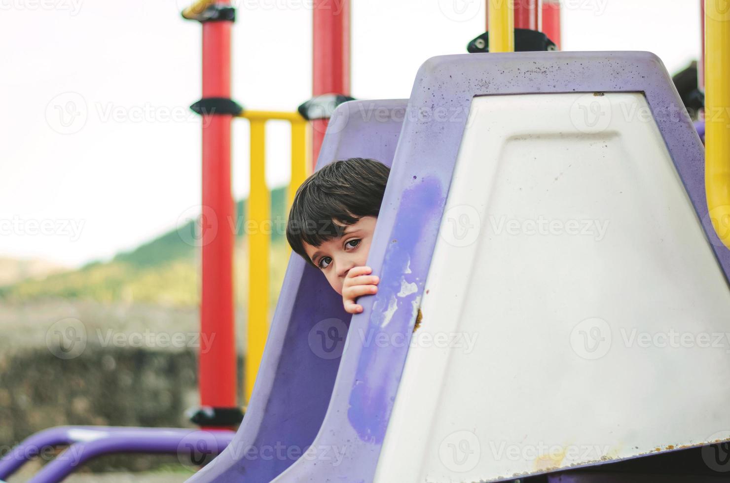 happy child playing on the slide photo