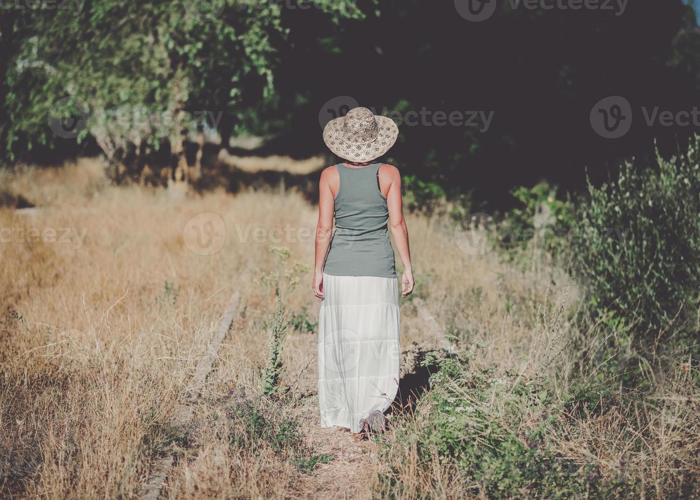 Back view of a Pensive Young Woman in the field photo