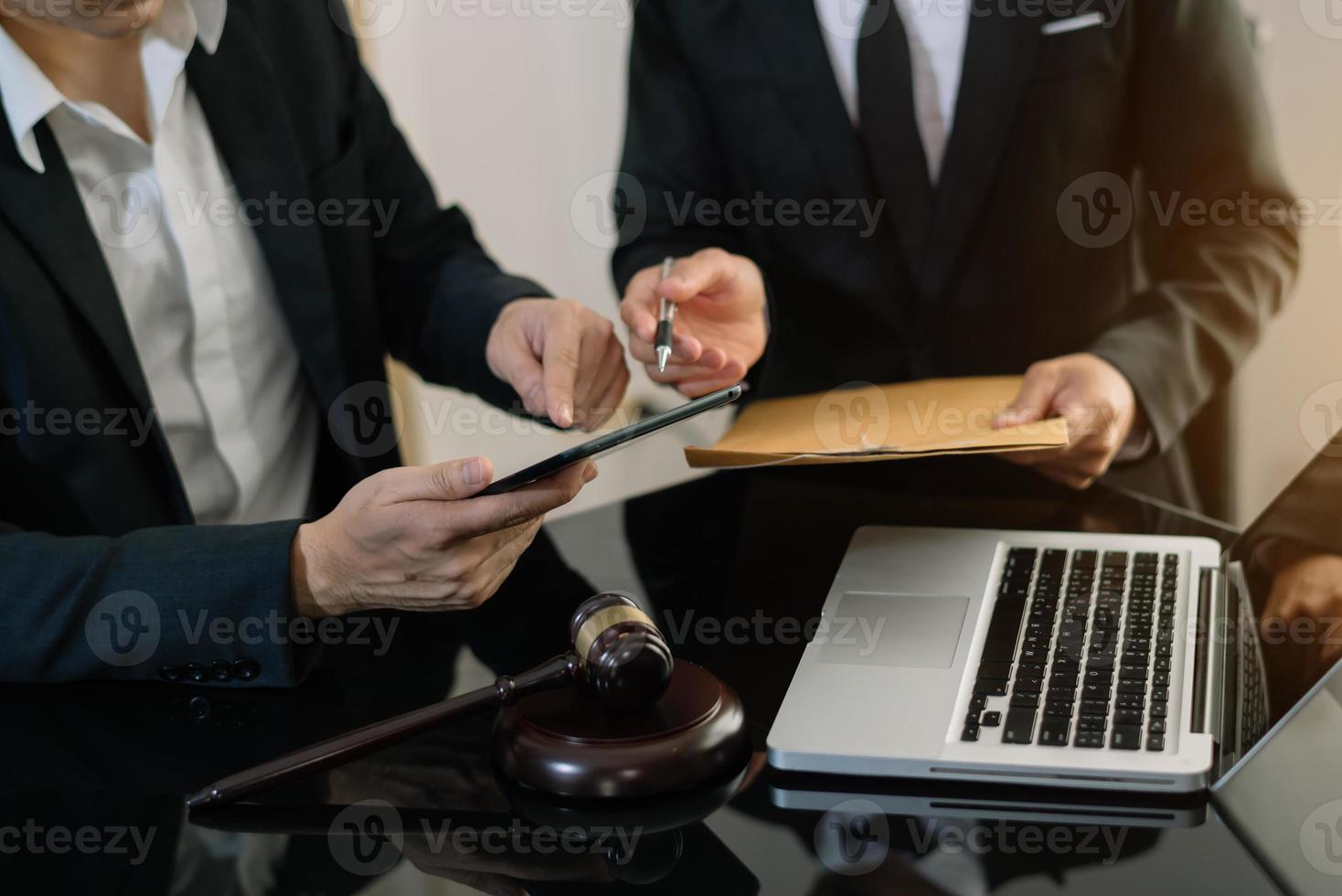 empresarios y abogados discutiendo documentos contractuales sentados a la mesa. conceptos de derecho, asesoría, servicios legales. a la luz de la mañana foto