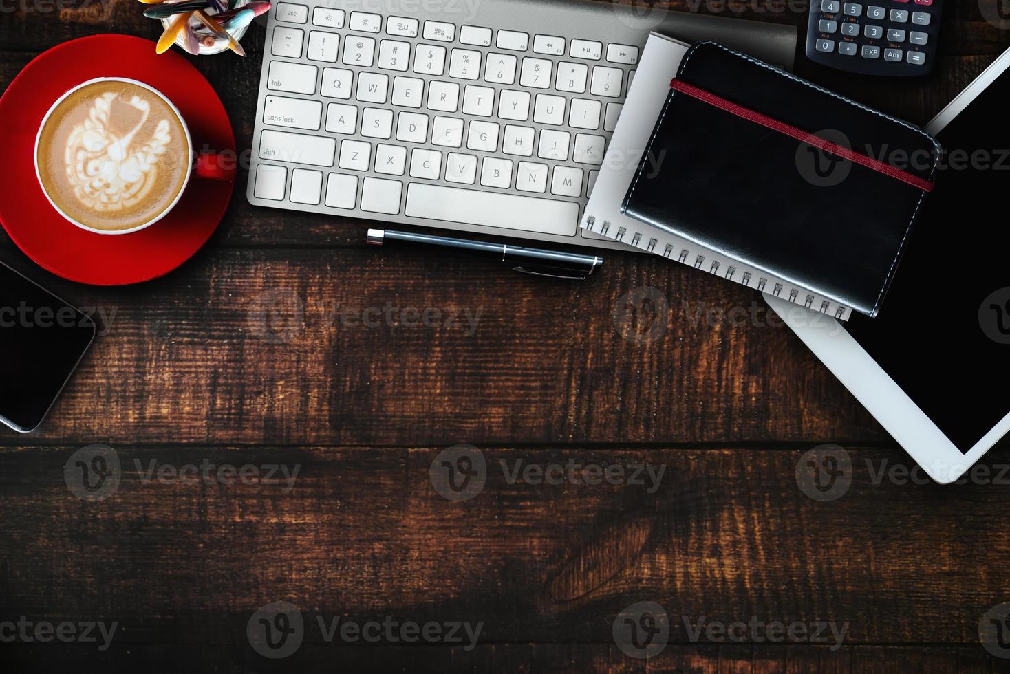 Wood office desk table with a lot of things tablet, laptop ,smartphone ,notepad and coffee cup notepad . Top view with copy space virtual interface icons screen. photo