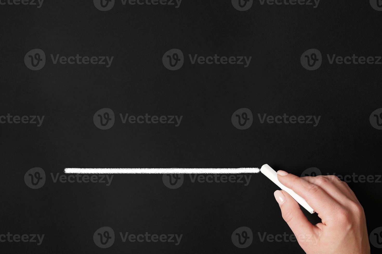 hand drawing chalk line on chalkboard photo