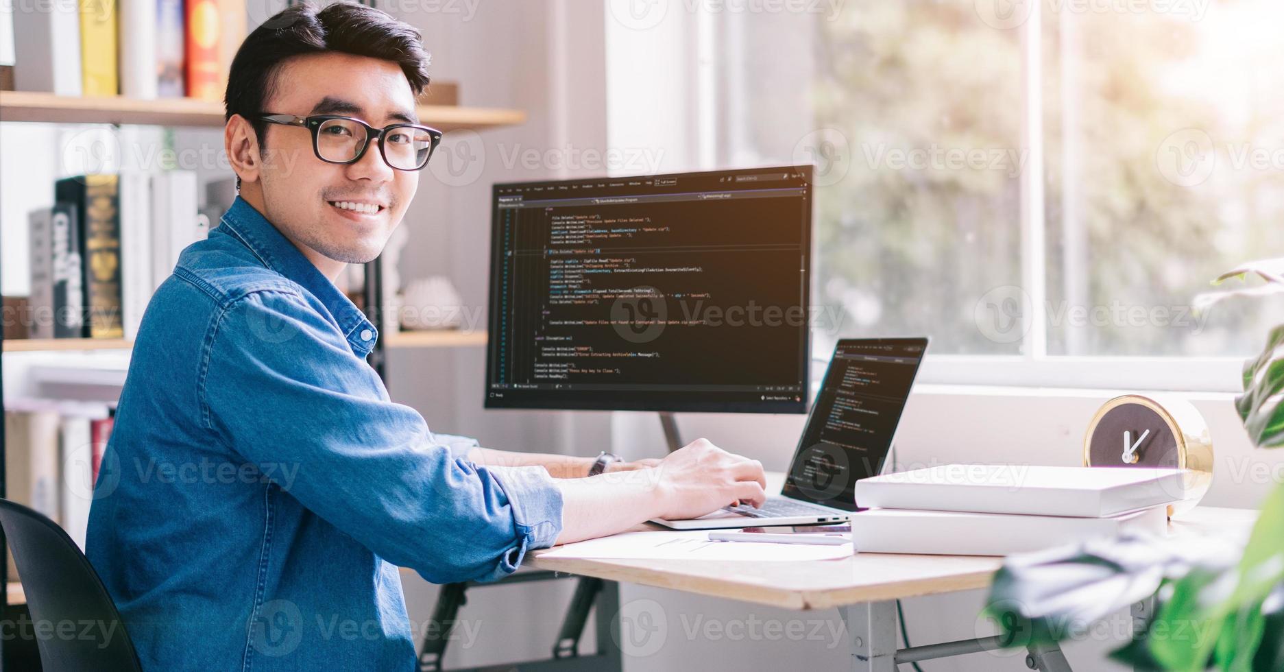 Young Asian programmer working at office photo