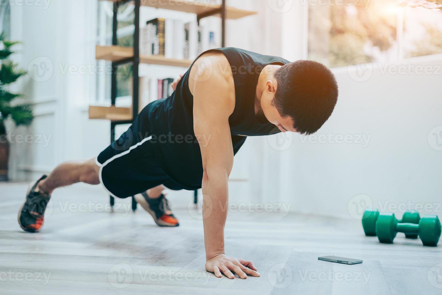 joven asiático haciendo ejercicio en casa foto