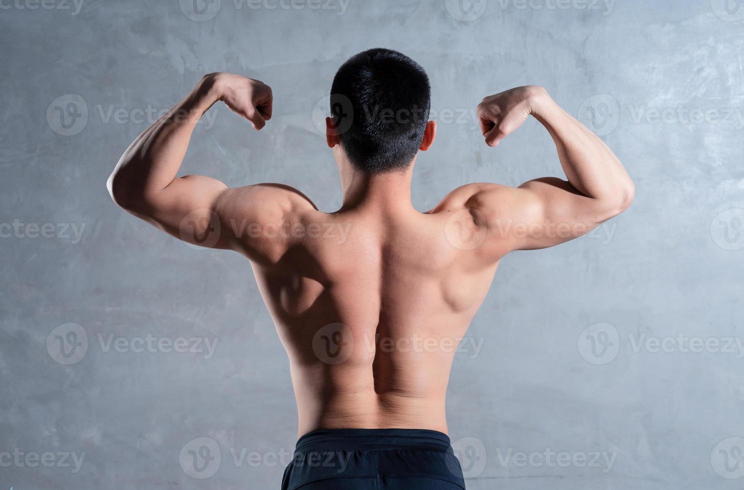 Muscular Asian man posing on gray background photo