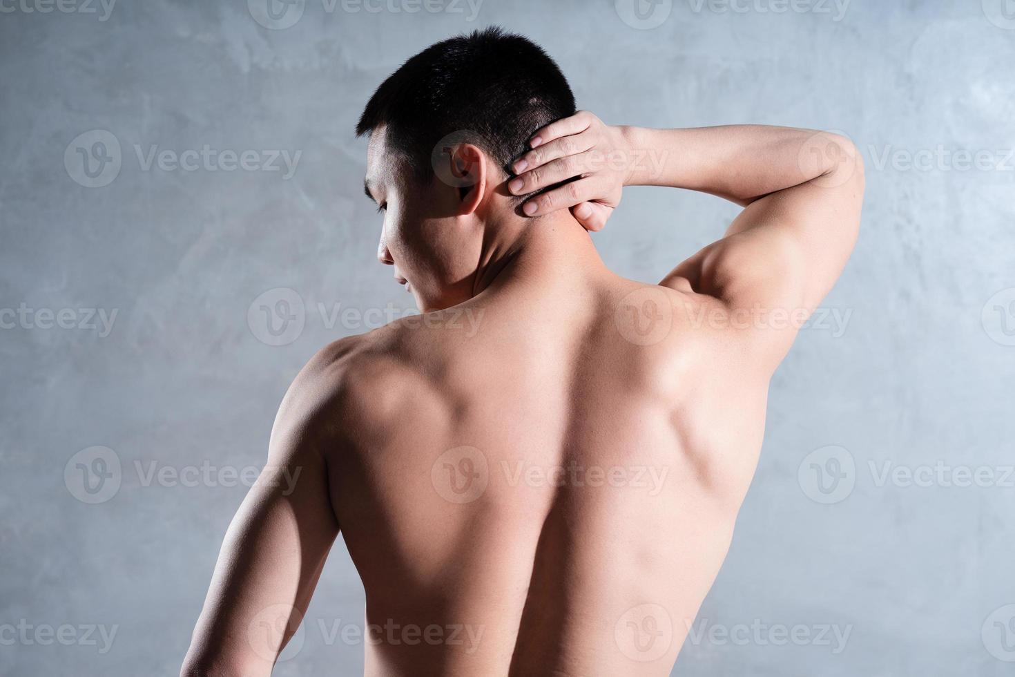 Muscular Asian man posing on gray background photo