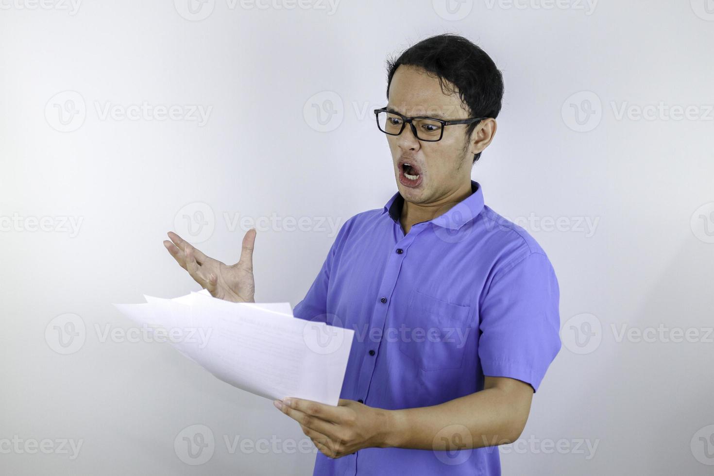 Young Asian man is shocked and surprised with the white mail message or the bill. photo