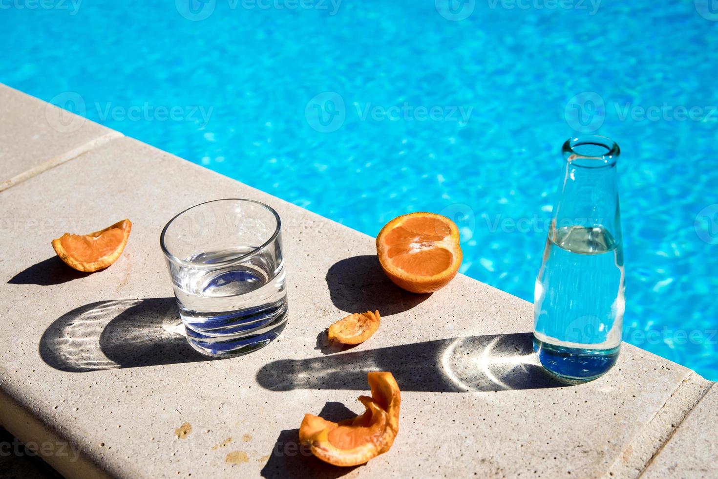 glasses and fruits next to the pool photo