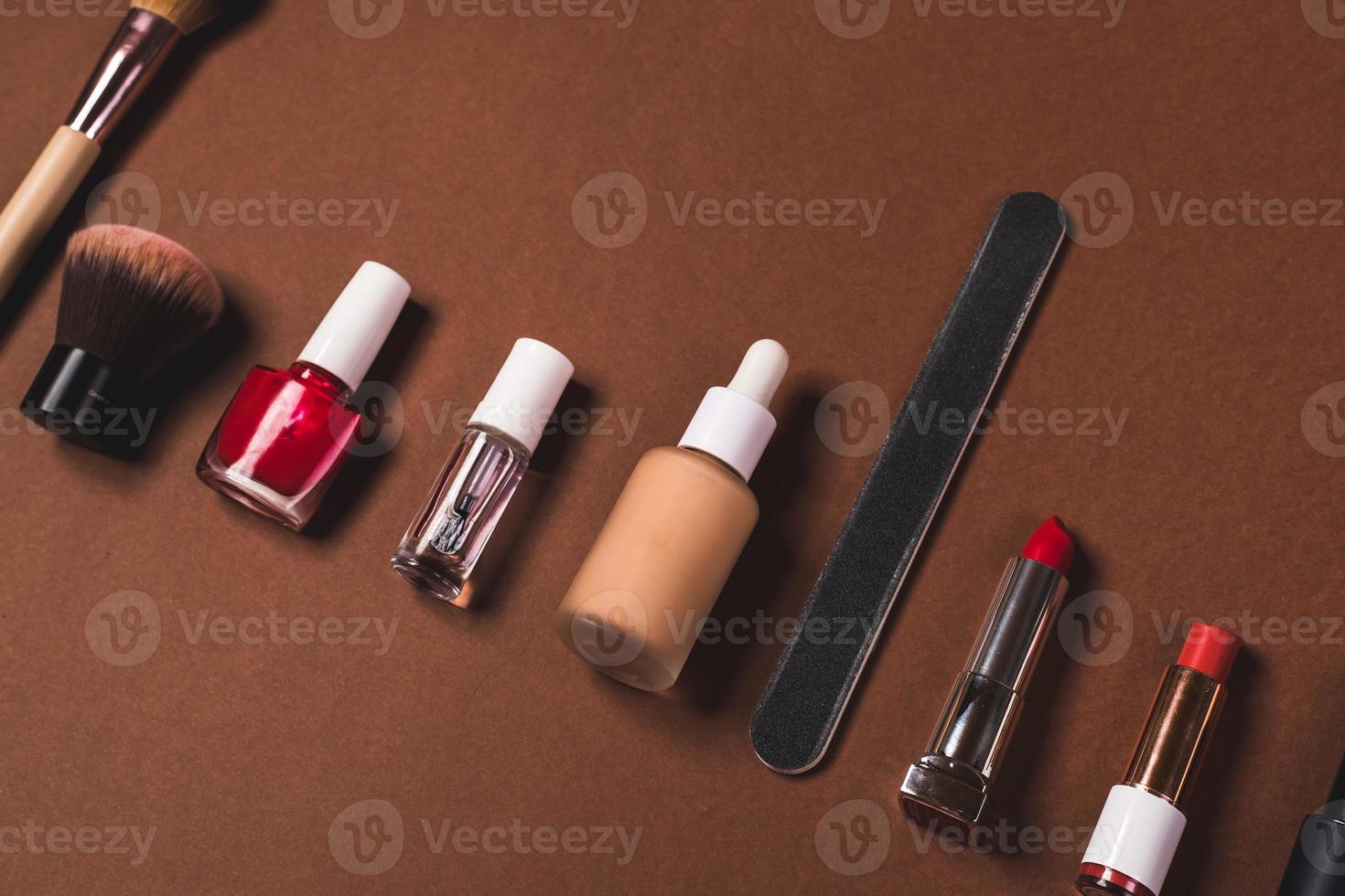 make up stuff on a brown red and cream color background photo