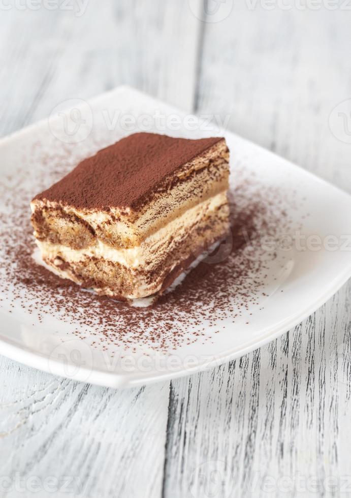 Portion of tiramisu on the white plate photo