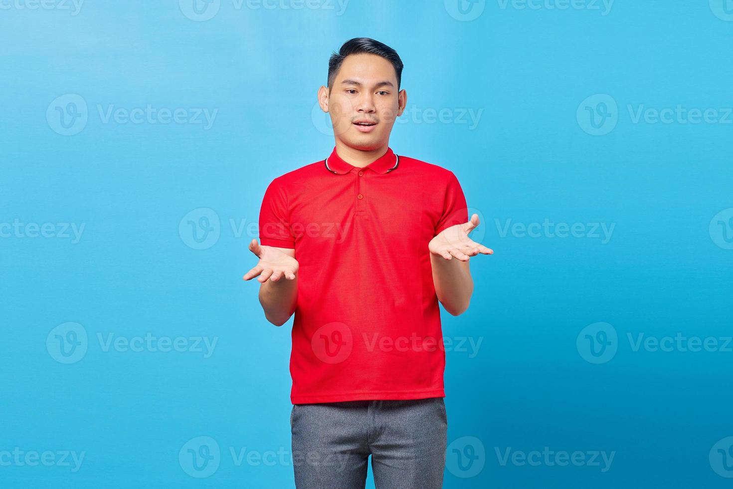 Portrait of handsome young Asian man feeling flustered and confused, with dumb expression and stunned to see something unexpected on blue background photo