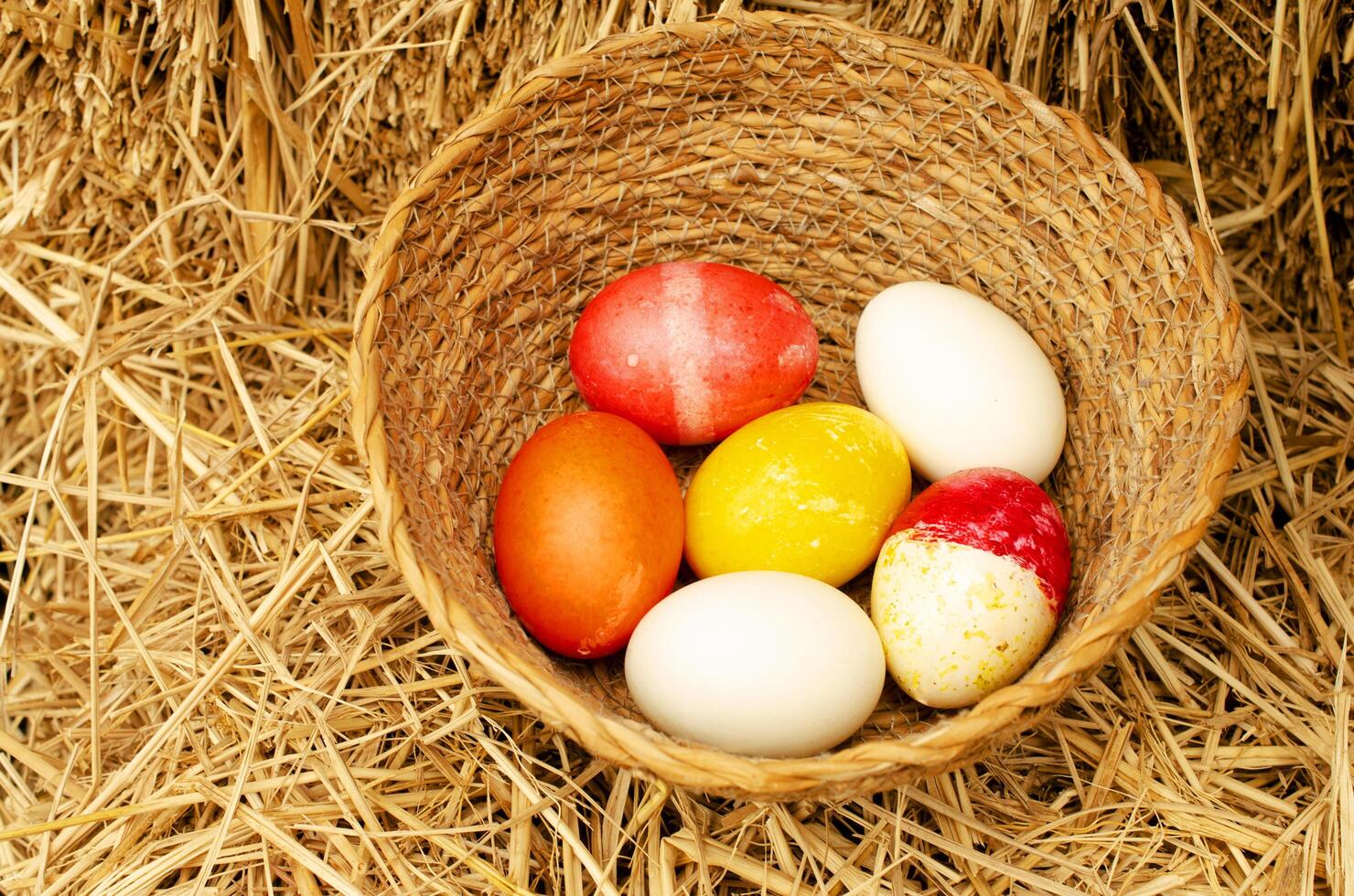 Easter eggs in the basket on straw backgrounds photo