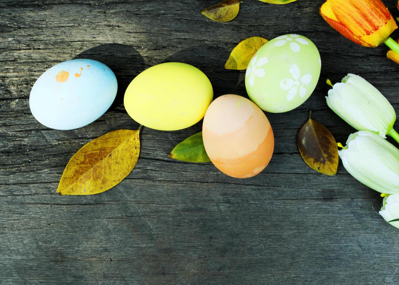 huevos de pascua y hojas sobre fondos de madera viejos arriba foto