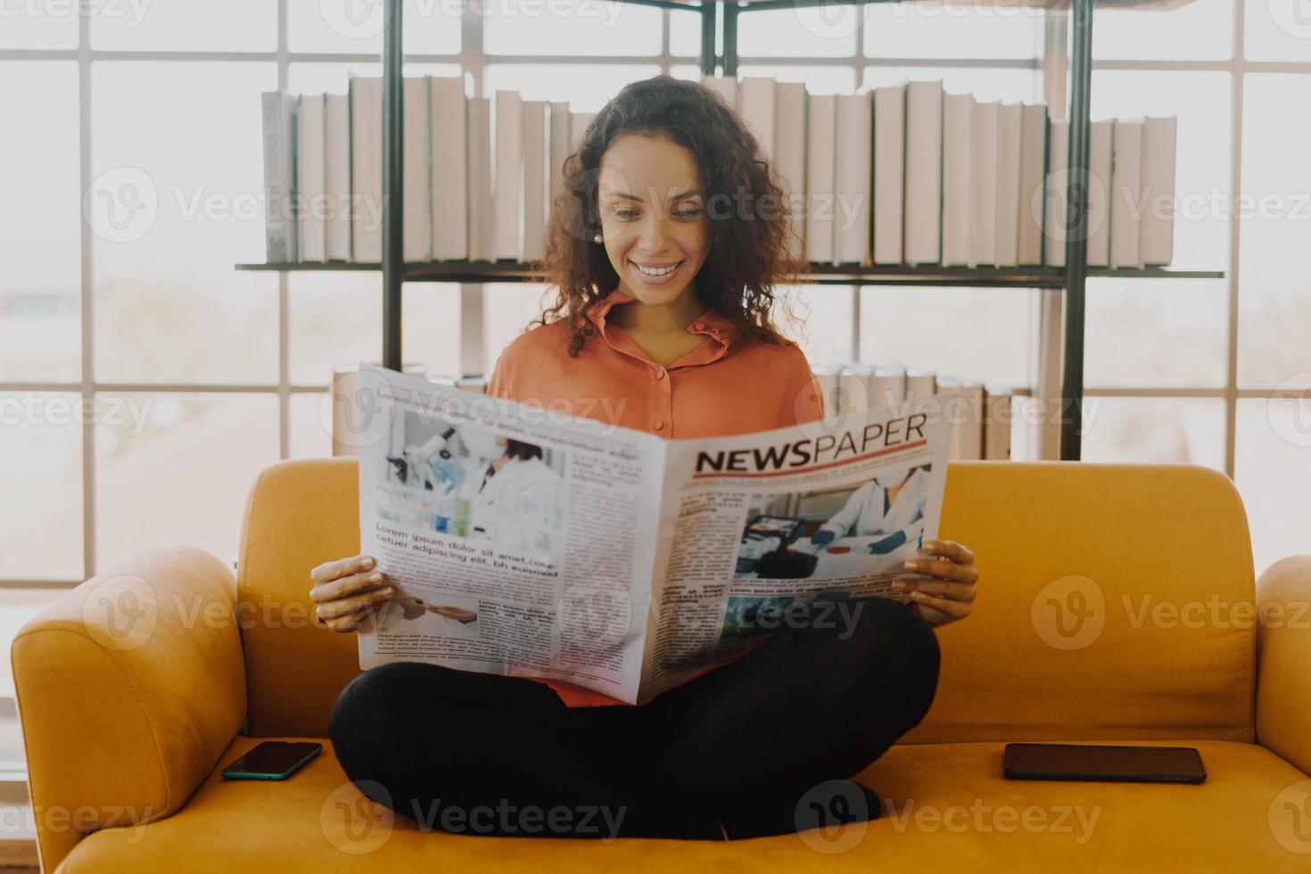 Latin America woman reading newspaper on sofa photo