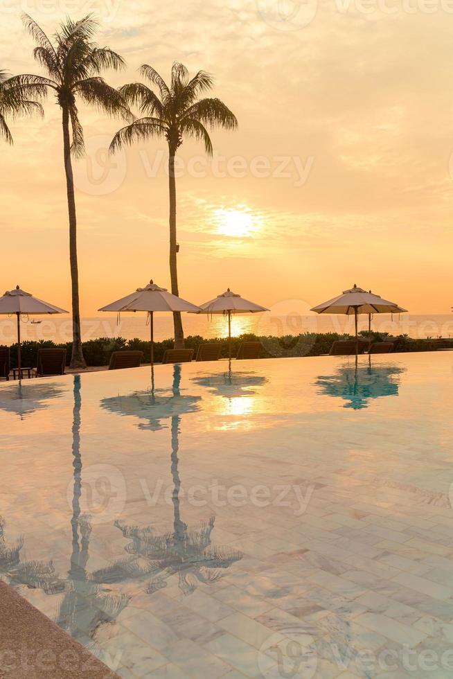 umbrella with bed pool around swimming pool with ocean sea background photo