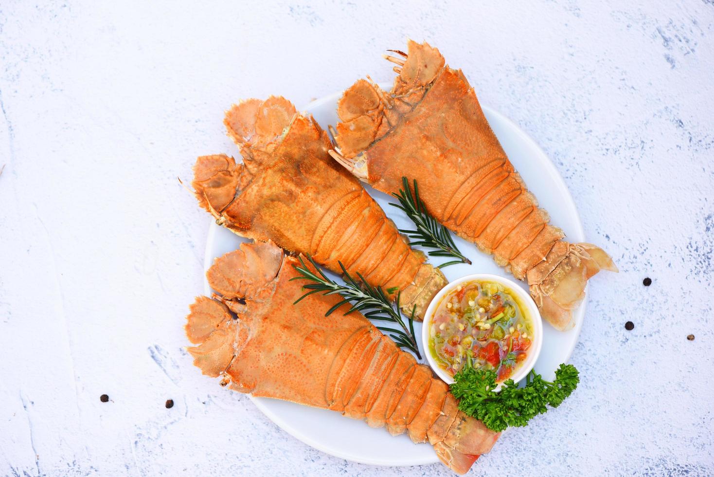 Fresh slipper lobster flathead boiled cooking with parsley rosemary in the seafood restaurant, Flathead lobster shrimps served on white plate and seafood sauce, Rock Lobster Moreton Bay Bug photo