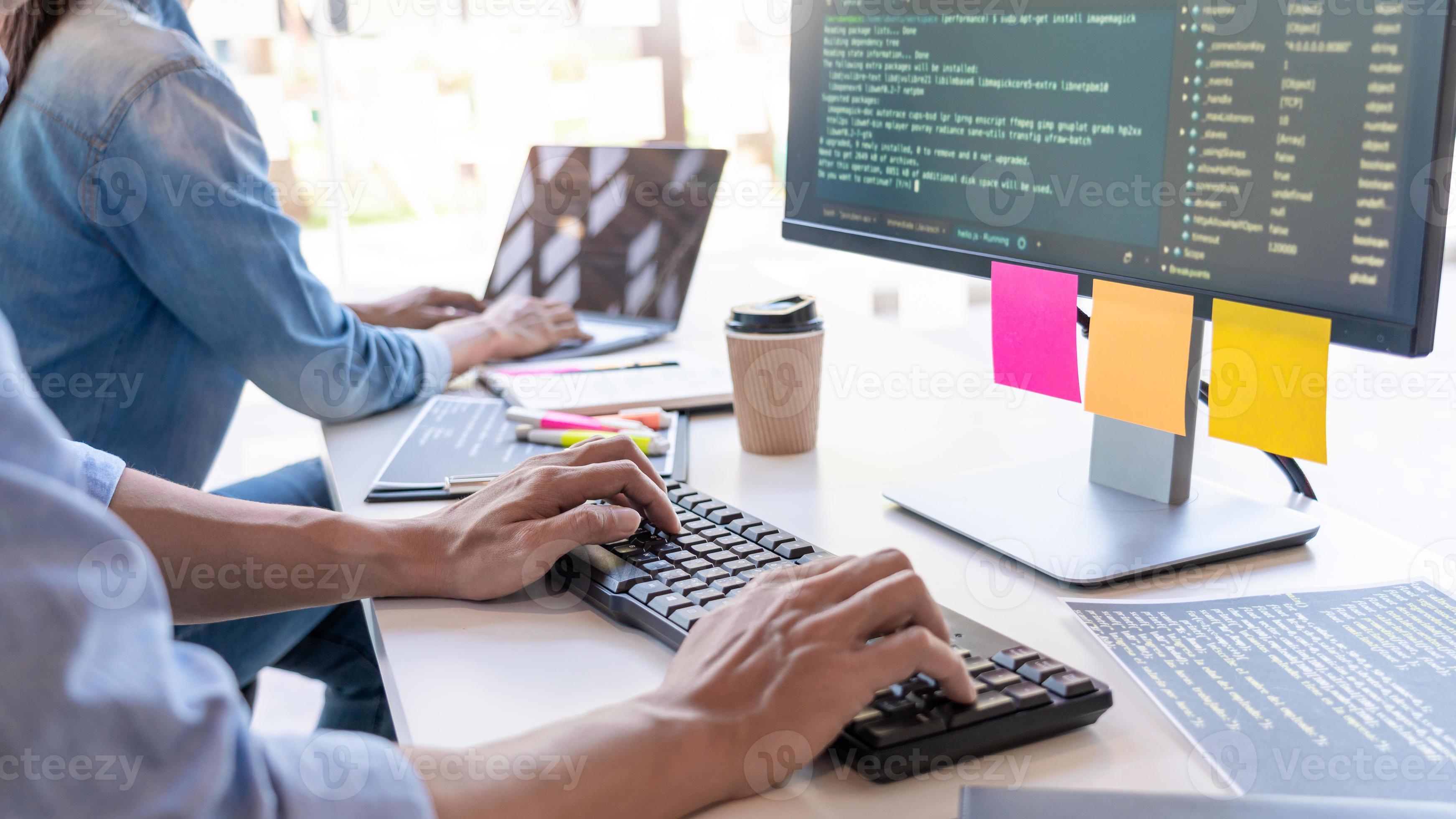 Young startup Programmers Sitting At Desks Working On Computers screen ...