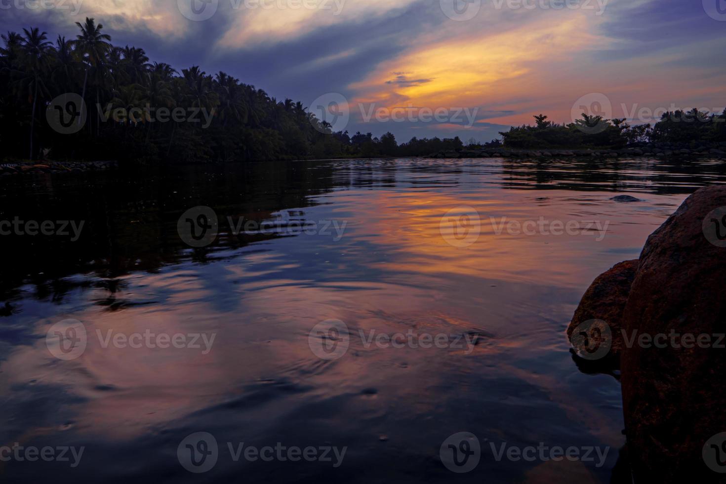 Beautiful calm coastline landscape at sunrise with rocks photo