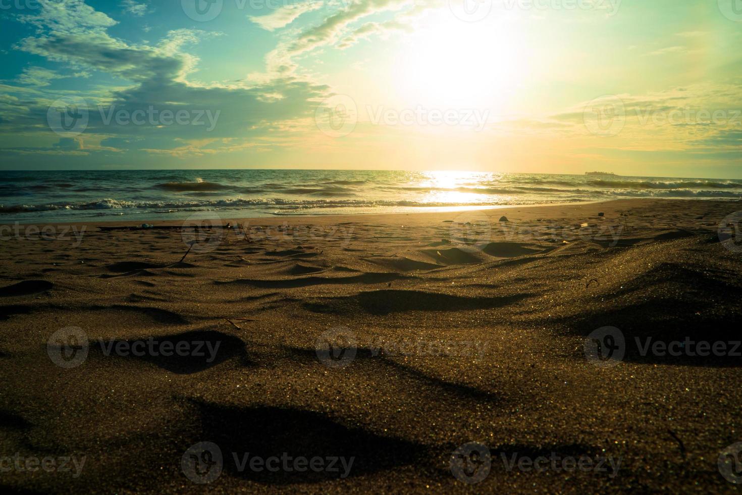 paisaje de playa de arena del océano al atardecer foto