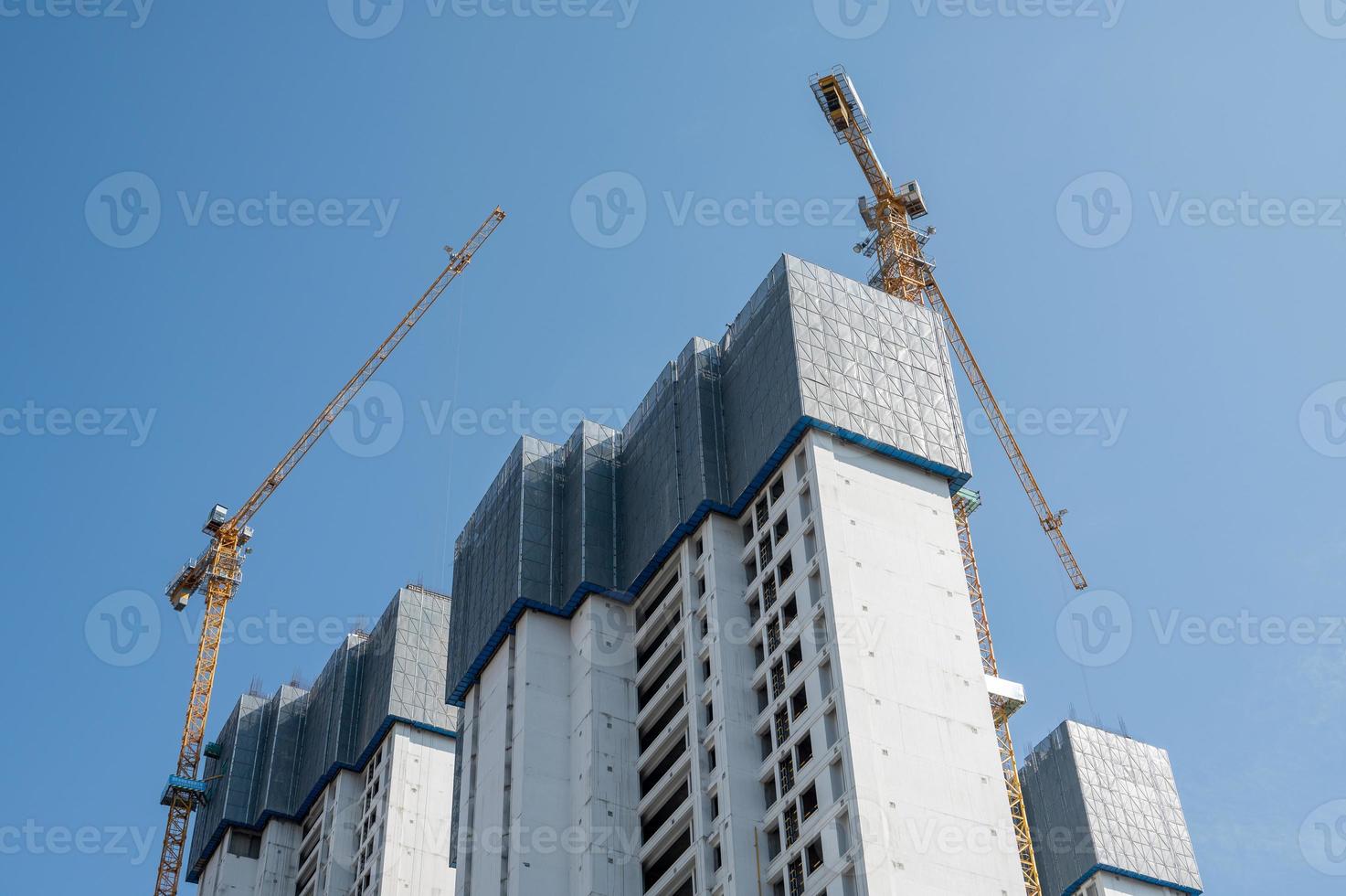 It's a fine day with blue sky, and the tower crane on the high-rise buildings in the city is under construction photo