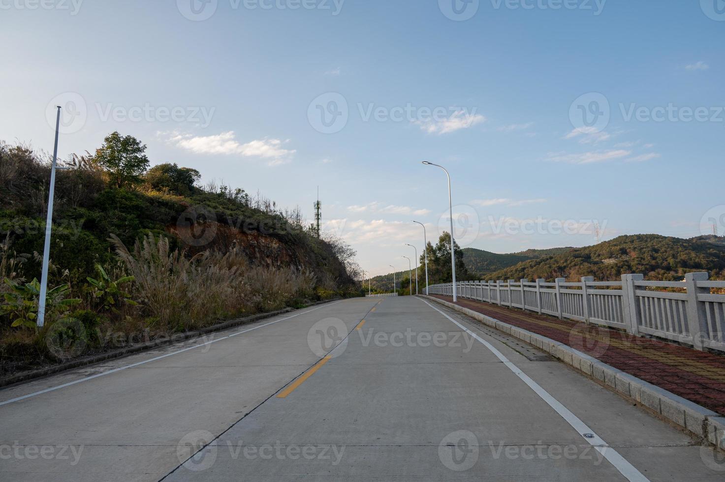 A road with two rows of street lights leading to the distance was photographed in the middle photo