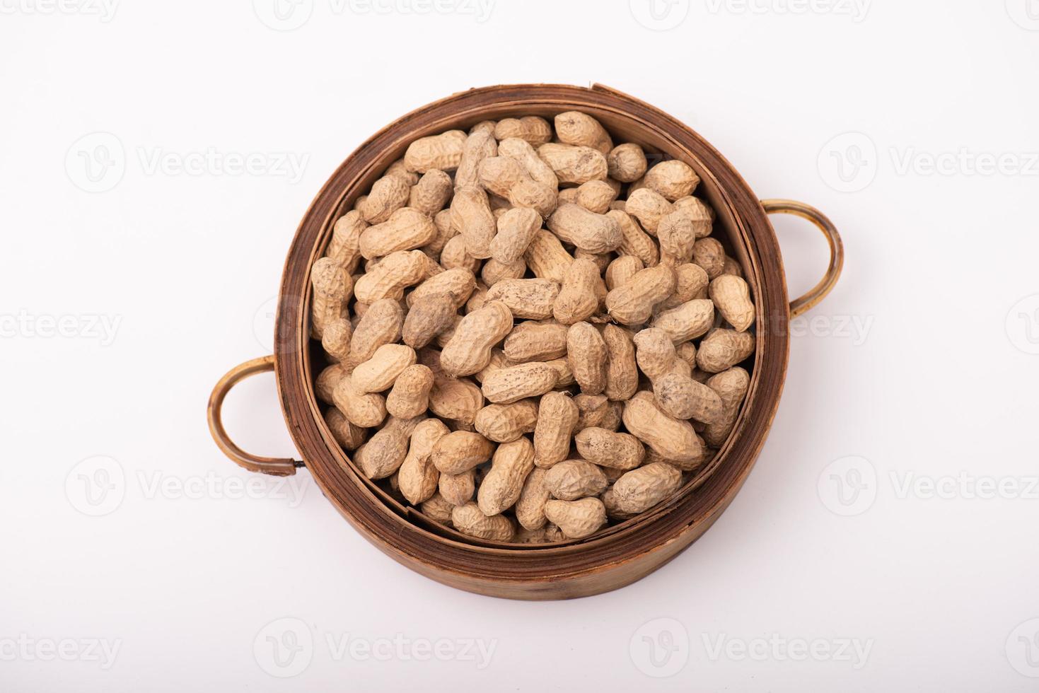 The peanuts in the round plate are on a white background photo