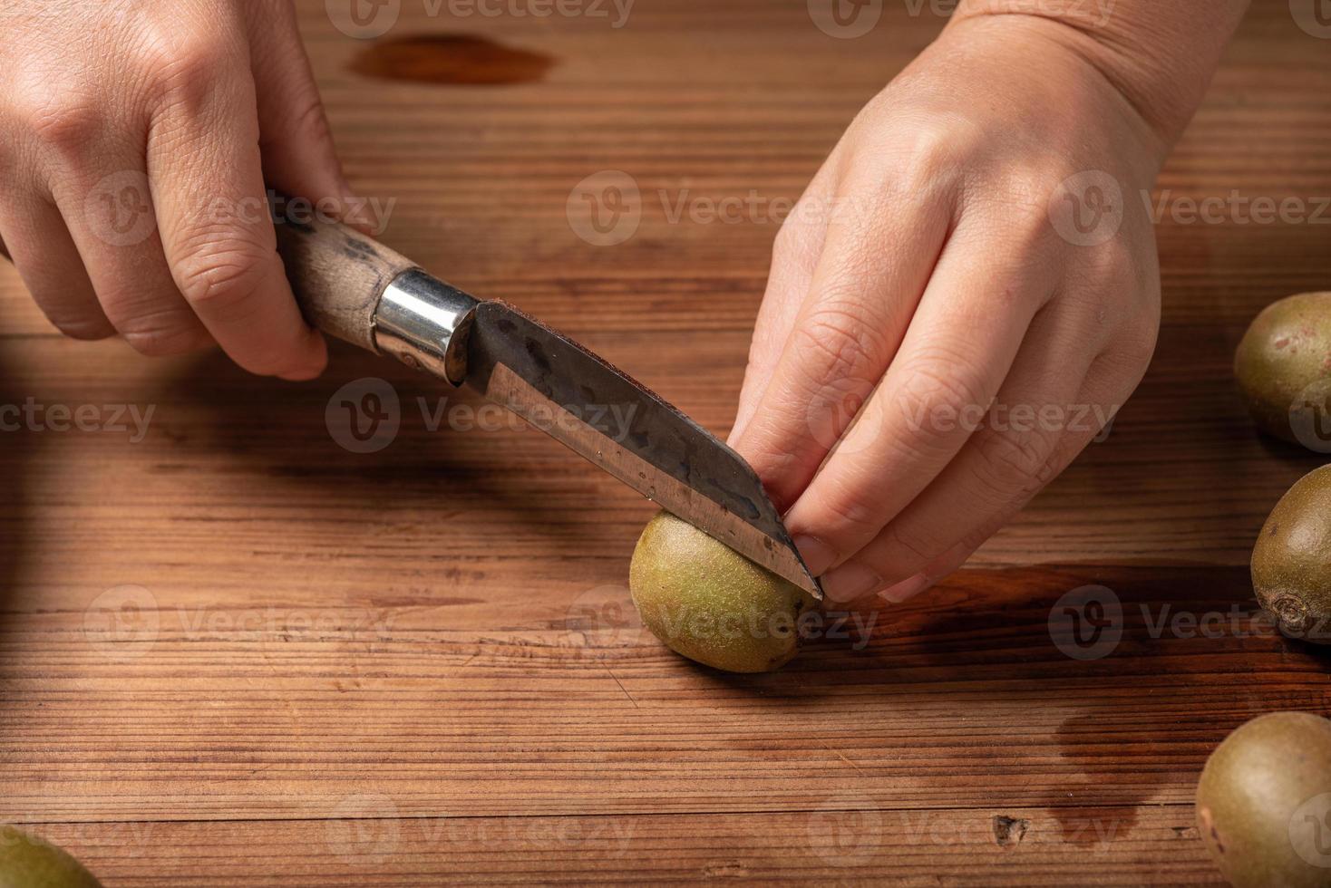 cortar kiwi maduro en una mesa de madera. foto