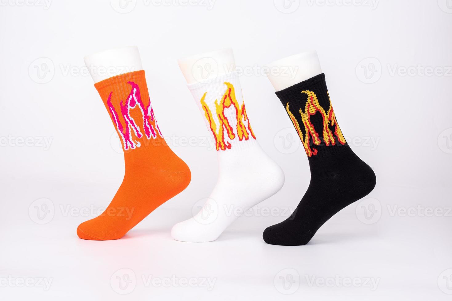 Three pairs of socks of different colors and styles are sleeved on the foot mold on a white background photo