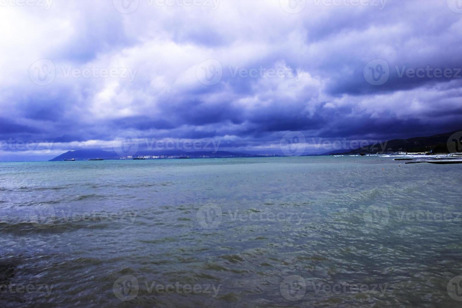 a través de las nubes sobre el mar se abre paso un rayo de sol foto