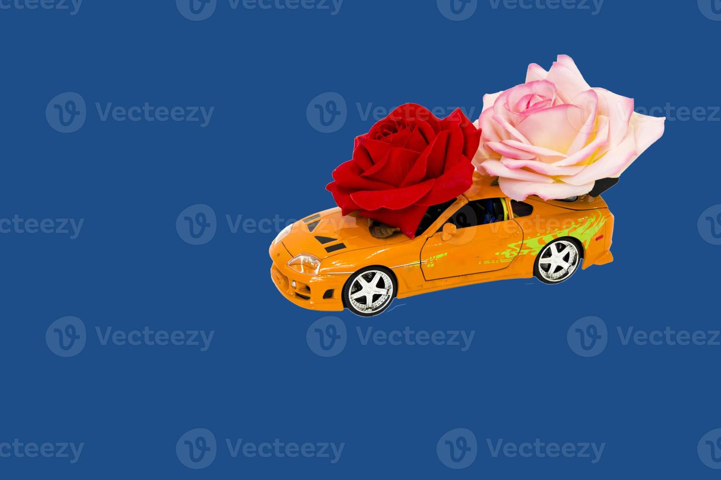 coche de juguete con rosas sobre fondo azul. foto